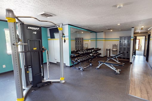 A gym with a variety of equipment including a weight machine and a bench press.