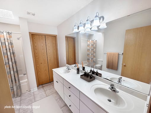 A bathroom with a white counter top and a white sink.