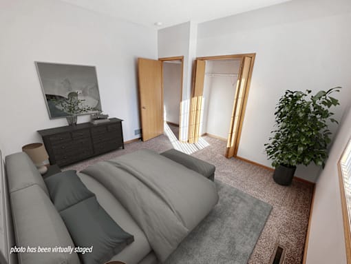 A living room with a grey couch and a plant.
