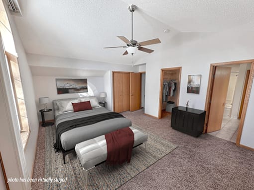 A bedroom with a bed, a dresser, and a ceiling fan.