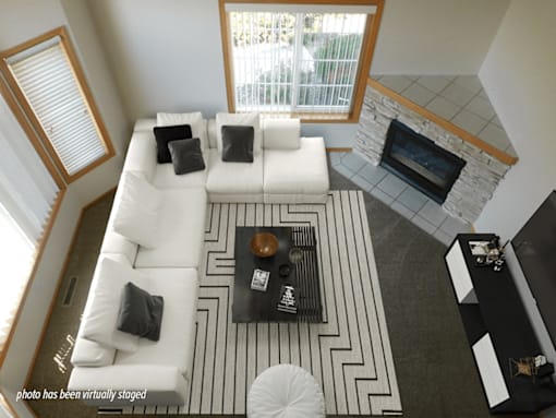 A living room with a white couch and a black and white rug.