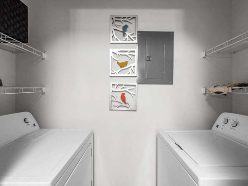a white laundry room with two washes and a dryer