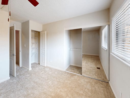 A room with a ceiling fan and carpeted floor.