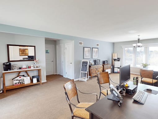 A room with a desk and chairs.