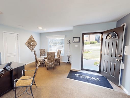 A room with a black door and a rug that says CINYON on it.