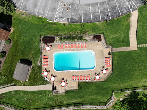 An aerial view of a pool surrounded by red chairs.