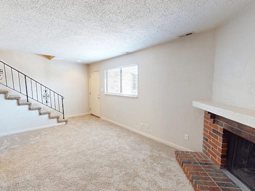 A room with a fireplace and a staircase.
