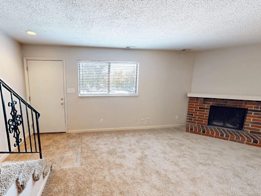 A room with a fireplace and a window with blinds.