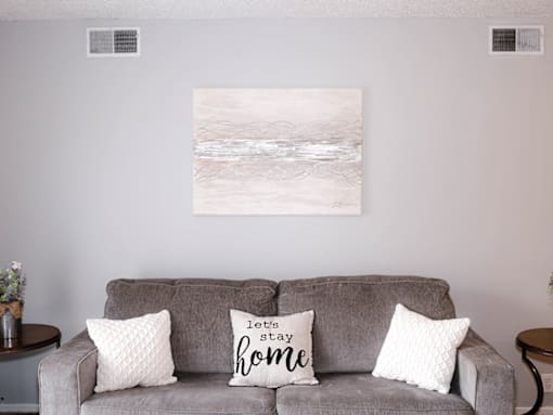 A grey couch with two pillows on it that say