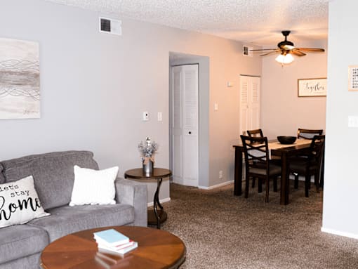 A living room with a grey couch and a brown coffee table.