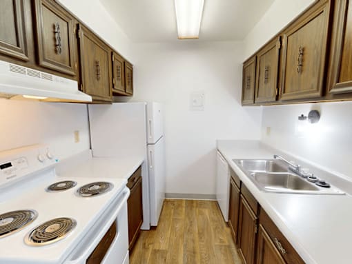 A kitchen with white appliances and wooden cabinets.
