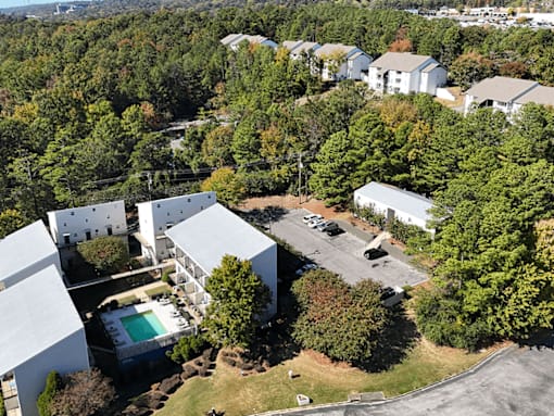 arial view of a house surrounded by trees and buildings