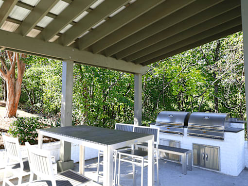 a patio with a table and chairs under a roof
