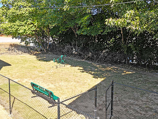 a park bench sitting in the grass next to a fence