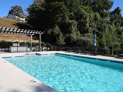 a swimming pool with black chairs and a resort style pool