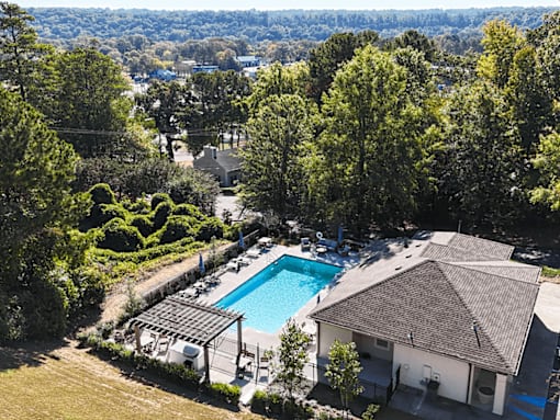an aerial view of a swimming pool surrounded by buildings and trees