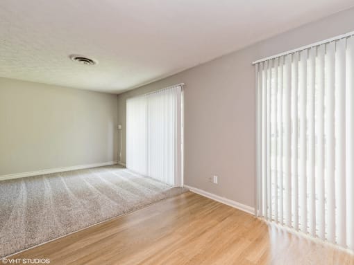 the living room and dining room of an apartment with windows