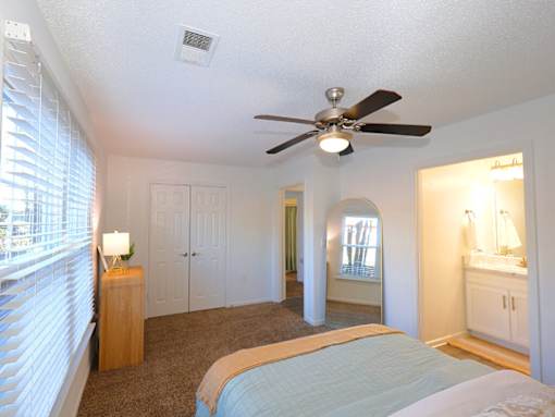 A bedroom with a bed, dresser, and mirror.
