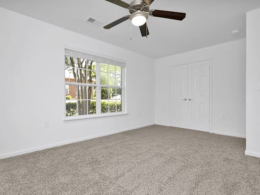 second bedroom with a ceiling fan and  carpet