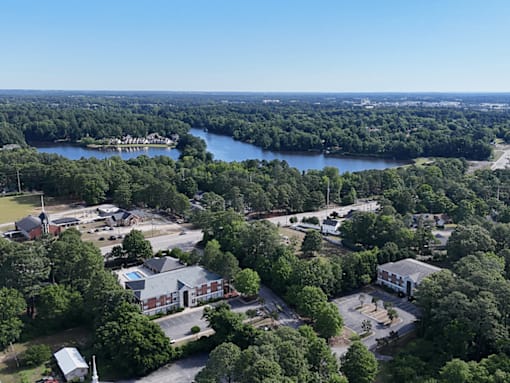 A bird's eye view of a residential area with a large body of water in the background.