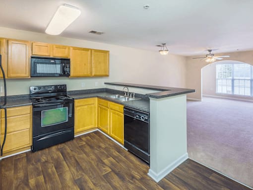 A kitchen with wood colored cabinets and dishwasher