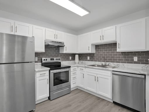 Apartment kitchen with cabinets and stainless steel appliances