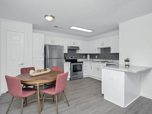 An open kitchen with a table and chairs.