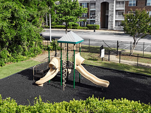 A playground with a slide and a green canopy.