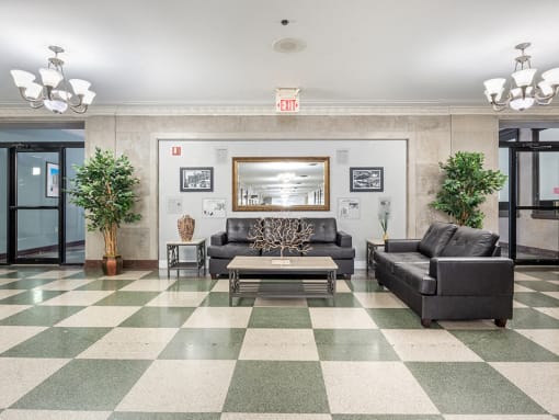 a lobby with couches and a coffee table on a checkered floor