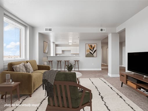 A living room with a couch, chair, and television.
