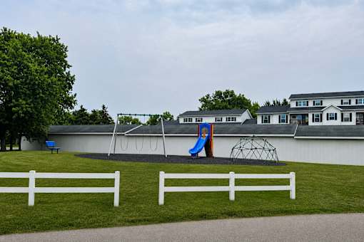 A playground with a slide and a swing set.