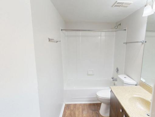 A white bathroom with a toilet, sink, and shower.