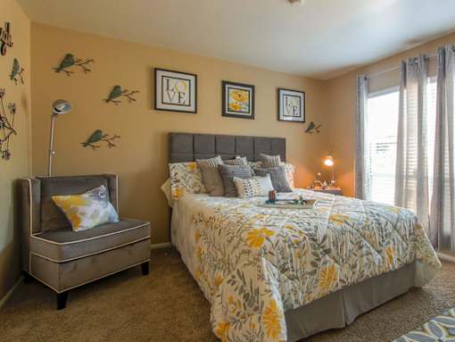A bedroom with a large bed and a bench.
