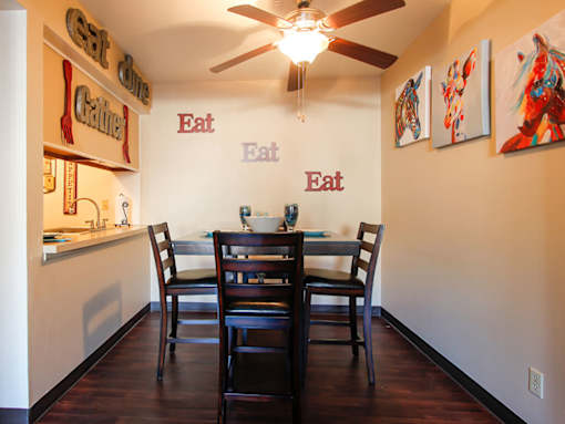 A dining room with a table and chairs.