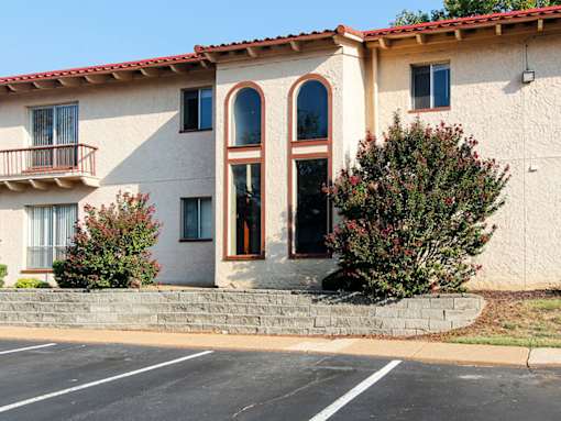 A building with a red tile roof and a balcony.