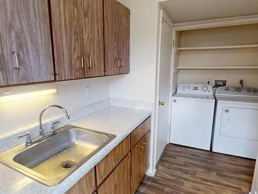 A kitchen with a sink and a washer and dryer.