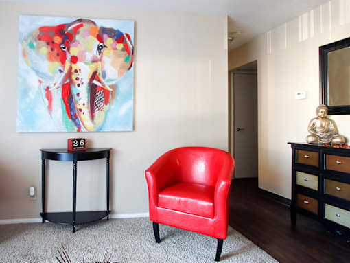 A red chair sits in front of a painting of a fish.
