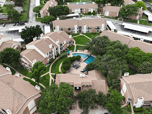 A bird's eye view of a residential area with houses and a swimming pool.