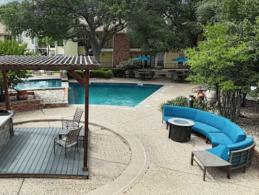 A backyard with a pool and a wooden deck.