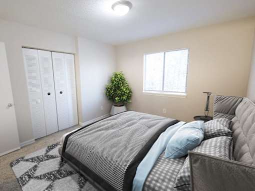 A bedroom with a large bed and a potted plant.
