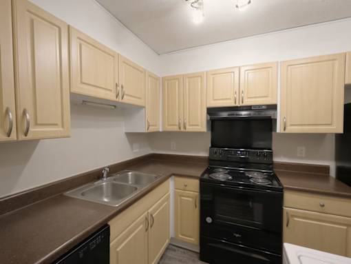 A kitchen with a black oven and brown countertops.