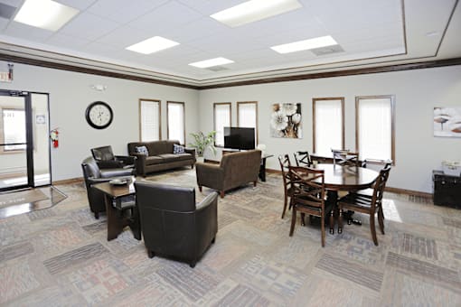A living room with a couch, chairs, and a table.