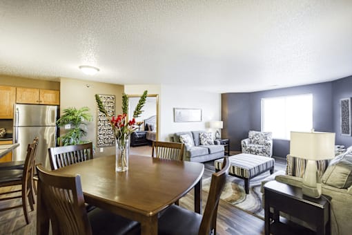 A dining room with a wooden table and chairs.