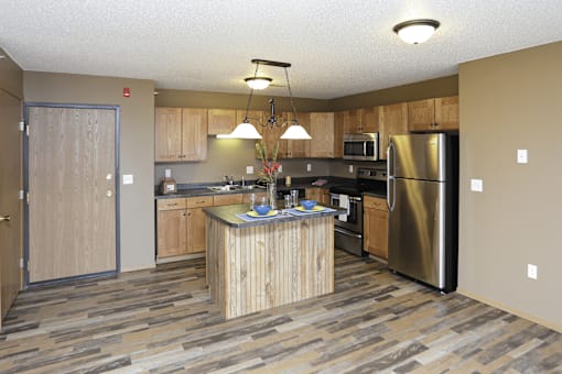 A kitchen with a wooden island and stainless steel appliances.