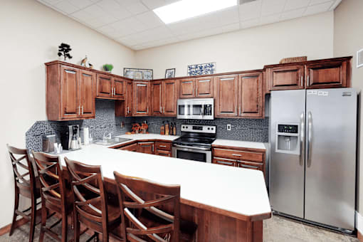 A kitchen with wooden cabinets and a white table.