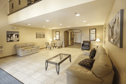 A living room with a couch, chairs, and a coffee table.