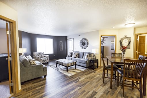 A living room with a grey couch and a wooden floor.