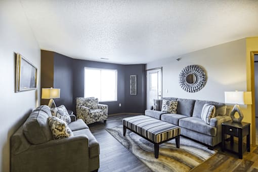 A living room with a grey couch and a wooden coffee table.