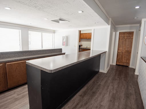 A kitchen with a black countertop and wooden cabinets.