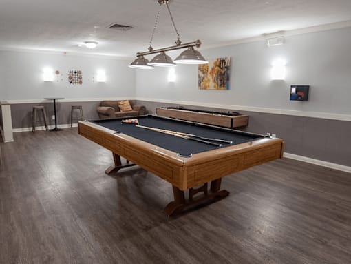A pool table in a room with a light hanging from the ceiling.